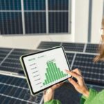 Woman_monitors_energy_production_from_the_solar_power_plant_with_a_digital_tablet._View_on_tablet_screen_with_running_program._Concept_of_new_technologies_in_alternative_energy