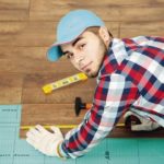 Carpenter_worker_installing_laminate_flooring_in_the_room