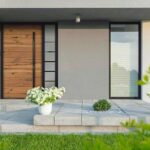 Grey_villa_with_new_design_entrance,_lawn,_glass_doors_and_decorative_plants