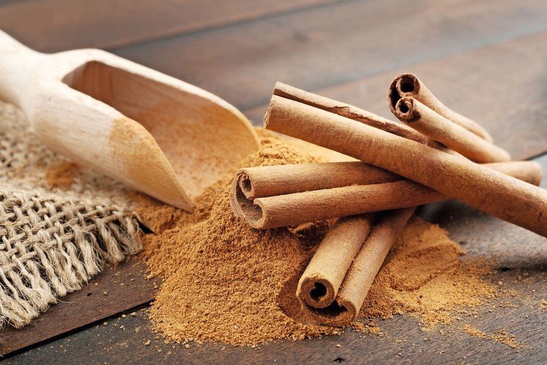 24551427_-_cinnamon_sticks_and_cinnamon_powder_in_wooden_scoop,_on_table