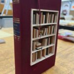 Weltliteratur en miniature: In echte Bücher eingefügte Regale sind gefüllt mit Minibüchern aus allerlei heimischen und exotischen Holzarten.