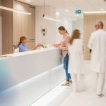 Blurred_motion_of_doctors_walking_in_clinic,_patients_sitting_on_chair.